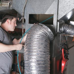 A ventilation cleaner man at work with tool